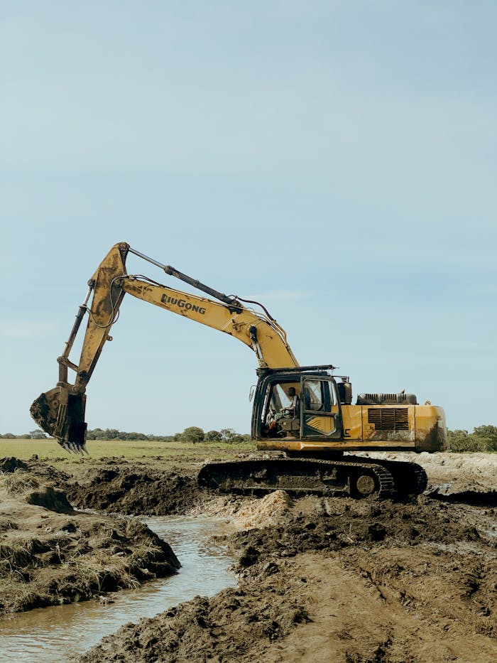 The Art of Drawing Readers In: Your attractive post title goes here Excavator operating in a muddy field, showcasing industrial construction machinery during a sunny day.
